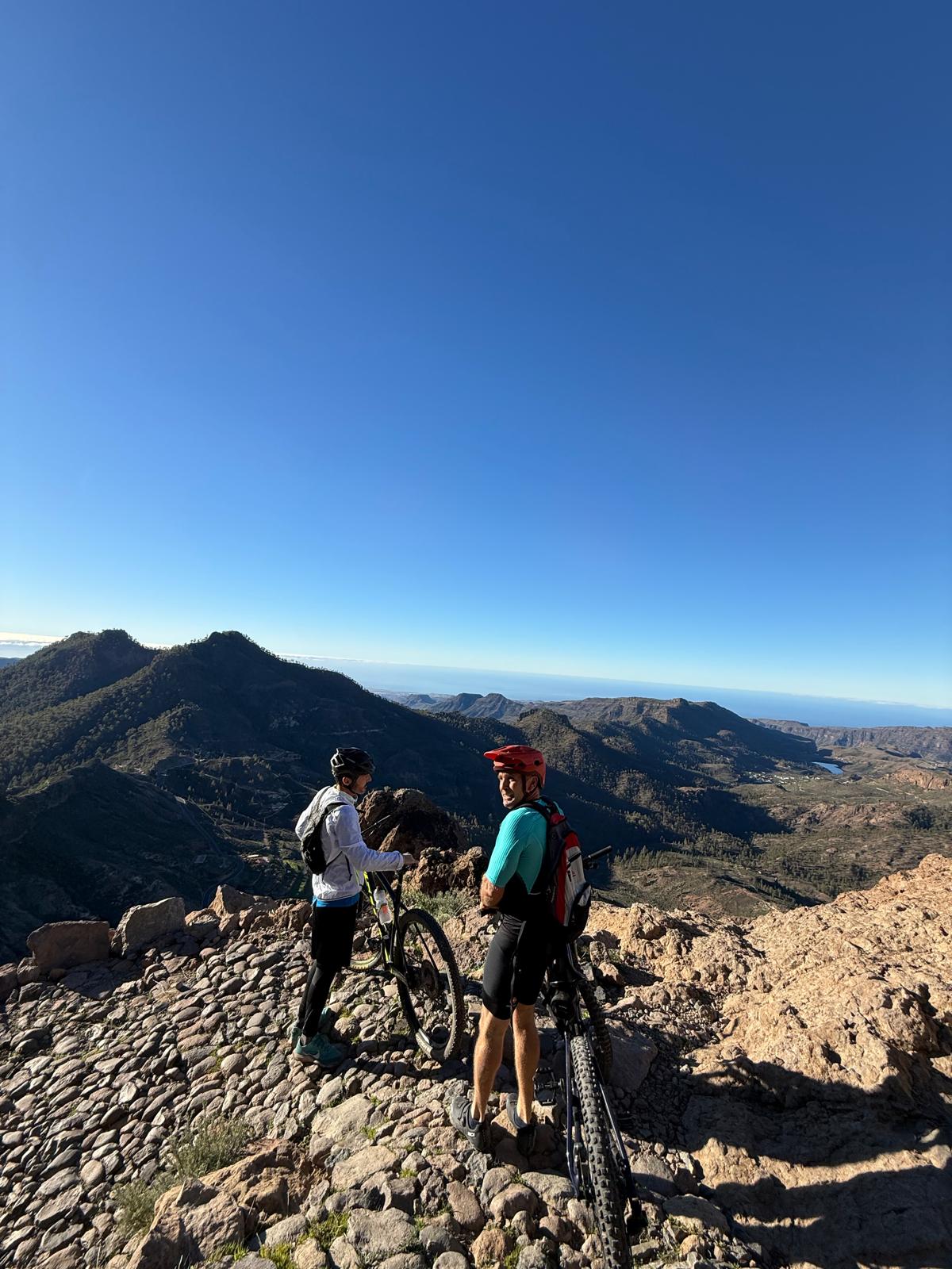Mountain bikers at the summit of Pico de las Nieves with panoramic views