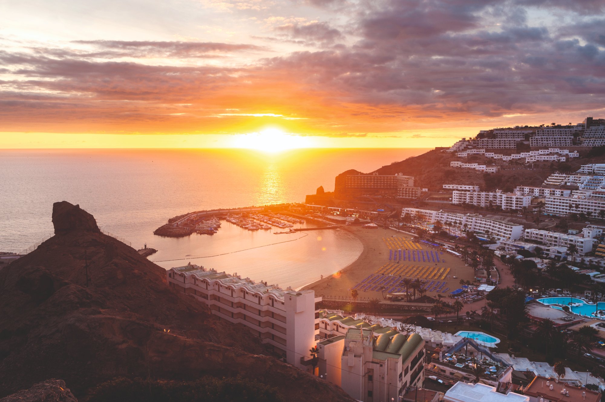 Stunning aerial sunset view over Puerto Rico beach and marina in Gran Canaria