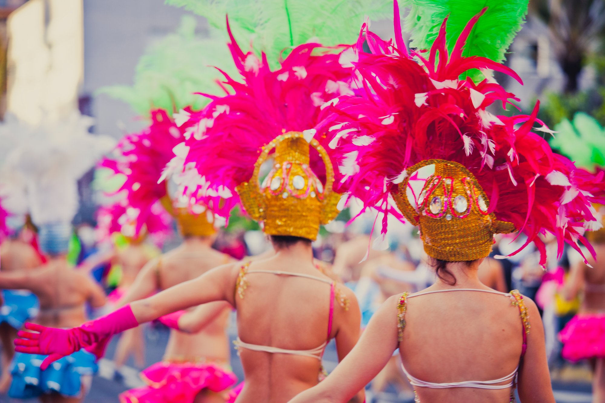 Carnival dancers in elaborate feathered costumes during Las Palmas Grand Parade