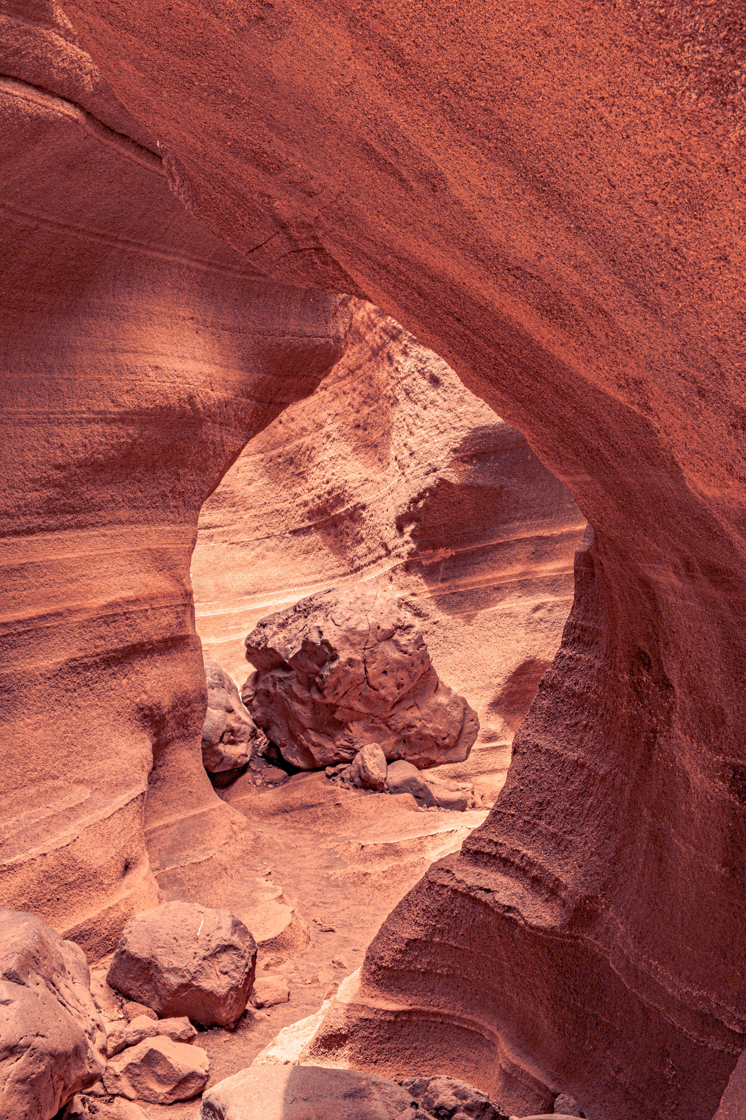 Dramatic red sandstone rock arch formation in a volcanic ravine of Gran Canaria